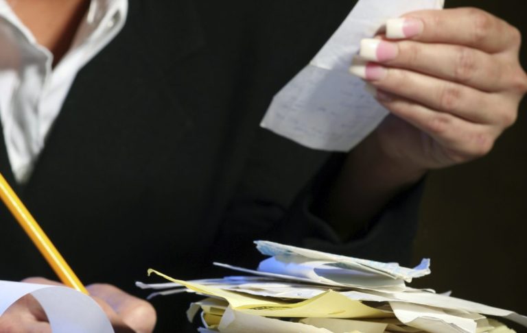 Femme réalisant la comptabilité sur un carnet.